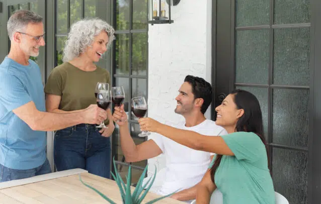 Family toasting on a patio outside their home